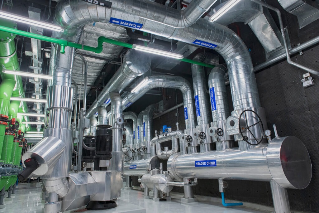 système CVC (chauffage, ventilation, climatisation) avec refroidisseur et chaudière, et réseau de tuyauteries d'eau glacée avec isolation pré-isolée dans une salle des machines